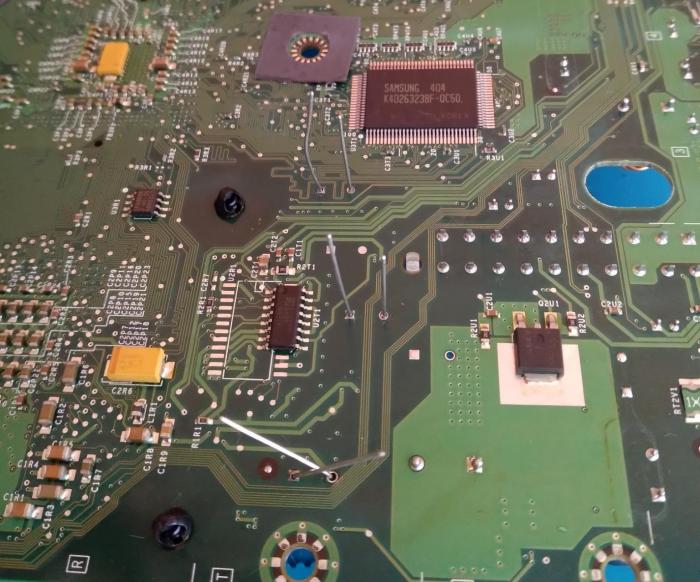 (underside of board with new capacitor legs sticking up, pre solder)